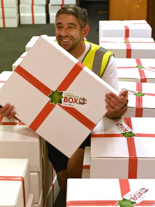 Christmas Box co-ordinator Jason Sargeant nestles among some of the completed boxes wrapped and...