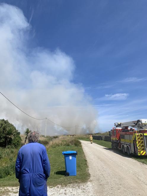 An Oreti Beach resident watches as Fire and Emergency New Zealand crews battle the fire.