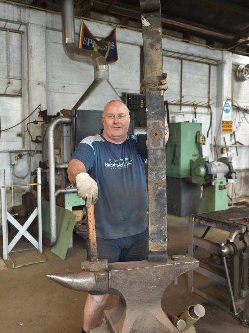 Brown & Cope owner Wayne Sheridan forges a leaf plate from the suspension system of an...