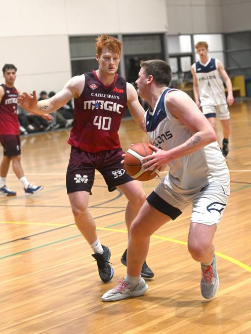Andy Bay Falcons guard Toby Lewis (right) tries to create space against Mid City Magic defender...