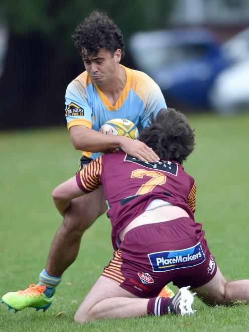 University hooker Oliver Hatch carries the ball as he is tackled by AU flanker McKenzie Hunter at...