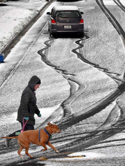A car and pedestrians try to navigate Colinsay St, Dunedin, on a wintry day last year. PHOTO:...