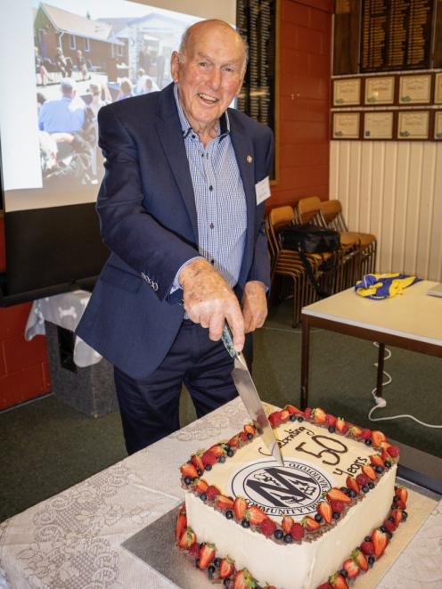 Former trustee and secretary John Levido, of Ranfurly, cuts the cake at the Maniototo Community...