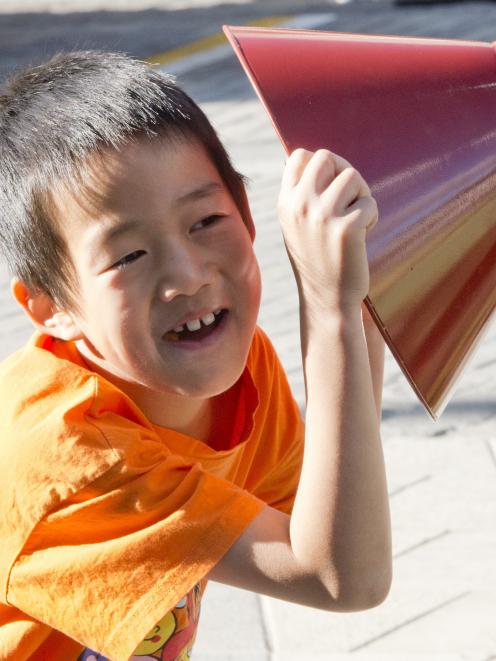 Dori Li, 8, waits for a reply from a voice tube in the playground area.