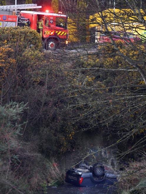 A ute lies upside down in Kaikorai Stream after it slipped on ice in Kaikorai Valley Rd yesterday...