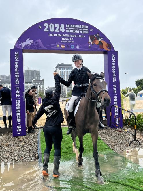New Zealand Pony Club coach Tui Willson, of Cromwell, congratulates Georgia Lewis on Blue Cat...