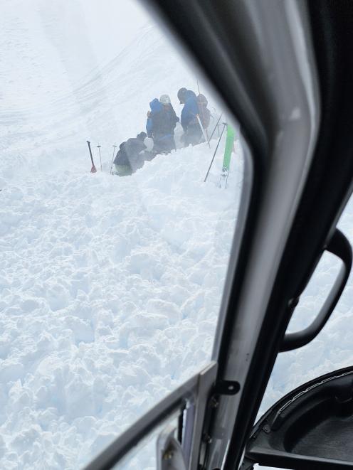 People dig to rescue a person buried by an avalanche in the mountains above Wānaka. PHOTO: JASON...