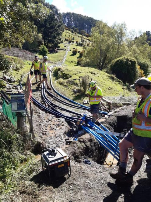 Council water crew members install temporary water pipes in the West Harbour area in Dunedin....
