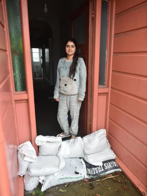 Loyalty St resident Navjot Dhillon stands behind a barricade of sandbags protecting her South...