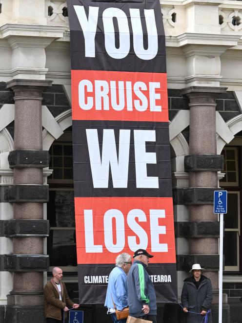 Climate Liberation Aotearoa protesters unveiled a banner from the Dunedin Railway Station...