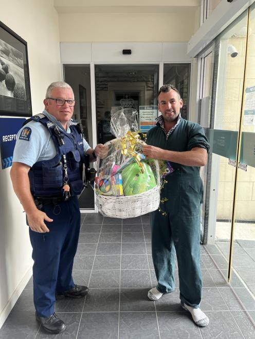 Oamaru Sergeant Tony Woodbridge receives the hamper from Brad Morton. Photo: Supplied

