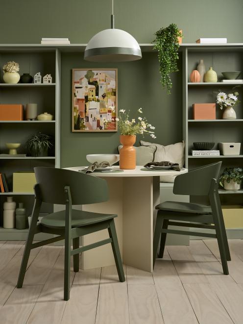 Sun-baked orange accents break up the lush greens of this dining room. Wall painted in Resene...