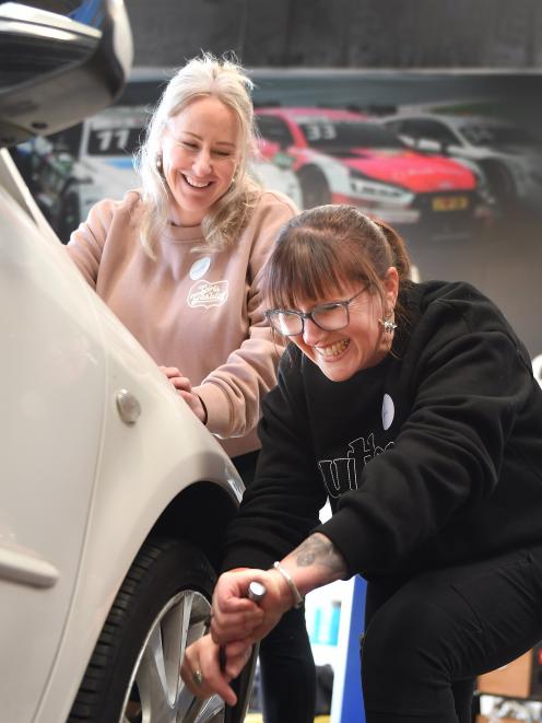 Diane Thomas removes wheel nuts to take off a tyre under the watchful eye of Melissa Hannan....