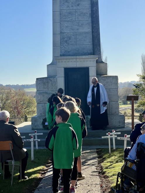 Archdeacon Wilkinson keeps an eye on Maheno School pupils from the steps of the Maheno cenotaph...