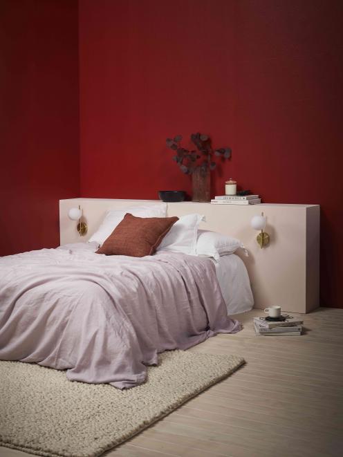 A colour-drenched room in deep red creates a cocooning and cosy bedroom. Walls painted in Resene...