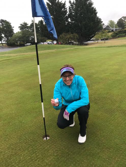 Mosgiel woman Tania Stevens, of Taieri Lakes Golf Club, removes the ball from No 7 hole after her second hole in one on the front nine. Photo: Supplied  
