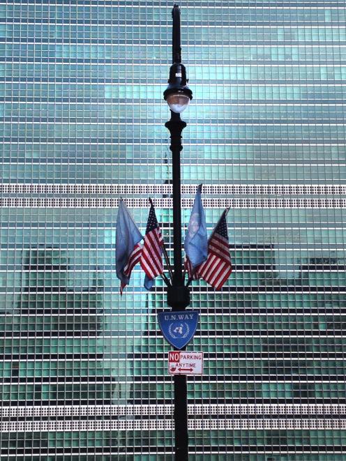 UN flags on a street lamp in front of the Secretariat Building at the United Nations in New York....