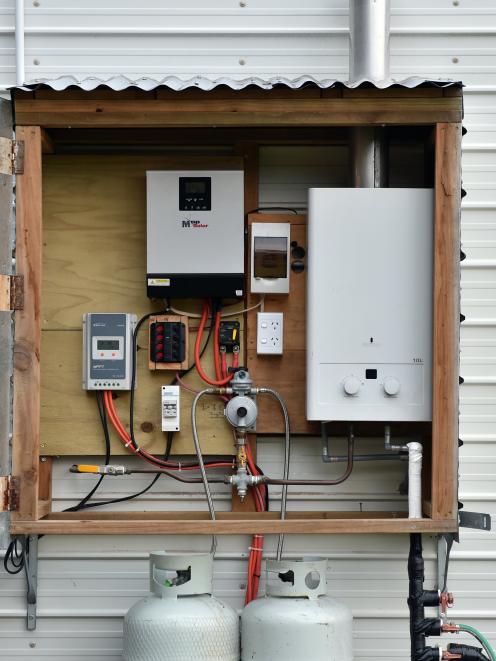 The power hub for the home is mounted on one end of the house.