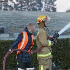 Queenstown man Jonathan Dunoyer assists a firefighter at Jacks Point yesterday. Photos by Blair Pattinson.