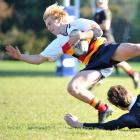 Waitaki Boys' High School replacement Bayley Sullivan ankle-taps John McGlashan College back Andrew McKenzie during an Otago premier schools game at McGlashan on Saturday. Photo: Christine O'Connor.