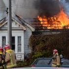 Firefighters battle to control a house fire in North Rd, Dunedin, yesterday. Photo: Linda Robertson