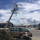A fallen power pole on Chicago St, Alexandra, leans over a car on Saturday. The pole was replaced on Sunday. Photo: Supplied