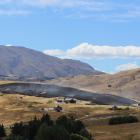 Smoke rises from a grass fire near homes at Threepwood Farm, beside Lake Hayes, yesterday morning. Photo: Thomas Whelan-Henderson