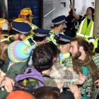 Police and protesters jostle, as officers try unsuccessfully to remove protesters who had linked...