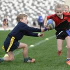 Sylvie Haig (8), of Fairfield School, tries to avoid the lunge by William Henderson (7), from the Columba College-John McGlashan College combined team. Photos: Gerard O'Brien