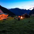 New Zeal clients eating dinner cooked by an on-site chef in a giant Nordic tipi in a remote...