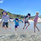 Jumping waves at Tomahawk Beach on December 22 are Edward (7) and Albert (5) Craw, and Max and...