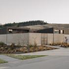 Clad in concrete block veneer and dark-stained cedar, both buildings are set around a courtyard...
