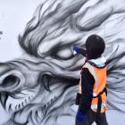 South Dunedin artist Koryu Aoshima creates a large mural of a dragon in King Edward St, as part...