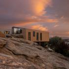 Simple "boxes" on steel poles float above the rock on this Alexandra site. The house was designed...