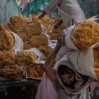 Asar Khan, 43, carries bundles of wrapped vermicelli after they are unloaded from the back of a...