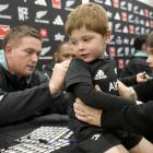 Highlanders and All Blacks prop Ethan de Groot signs the back of 3-year-old Levi Barsley. PHOTO:...