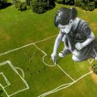 People play on a field containing an artwork by French-Swiss artist Saype at the Parc de la...