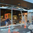 Contractors were on the job early yesterday fixing a window of the McKenzie and Willis store in...