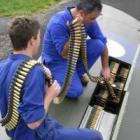 Engineers load ammunition belts into the wings of a Curtiss P-40 Kittyhawk in Auckland.
