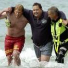 Brighton Surf Life Saving Club and Water Rescue Squad members surround Shane Hale (centre), who was rescued after spending 45 minutes trapped in the upturned hull of his boat. Photo by Gerard O'Brien. 