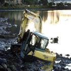 A digger is stuck in the mud at the Andersons Bay inlet yesterday.