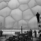 Chinese workers labour near the National Aquatics Center, also known as the Water Cube in Beijing...