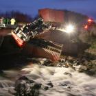 The upside down cab of a truck and trailer unit hangs over the side of a bridge near Browns, in...