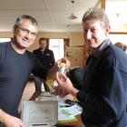 AgResearch scientist Scott Hardwick (left) hands Ikawai farmer Mark Caldwell phials of...