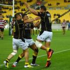 Alapati Leiua (right) of Wellington celebrates his try with teammates Frae Wilson (left) and Lima...