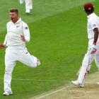 Corey Anderson of New Zealand celebrates after taking the wicket of Darren Bravo of the West...