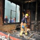 Southern regional  fire safety officer Barry Gibson checks the inside of the burnt-out Mornington...