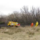 Volunteer firemen mop up after yesterday's estimated 2000sq m scrub fire in Springvale, near...