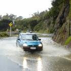 A car is driven through surface flooding on Portobello Rd, Dunedin, in late May. Photo by Jane...