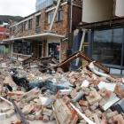 A car lies flattened by rubble fallen from a building beside the Lyttelton Hotel, in Lyttelton....